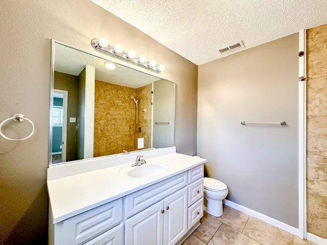 a bathroom with a sink a toilet and a mirror