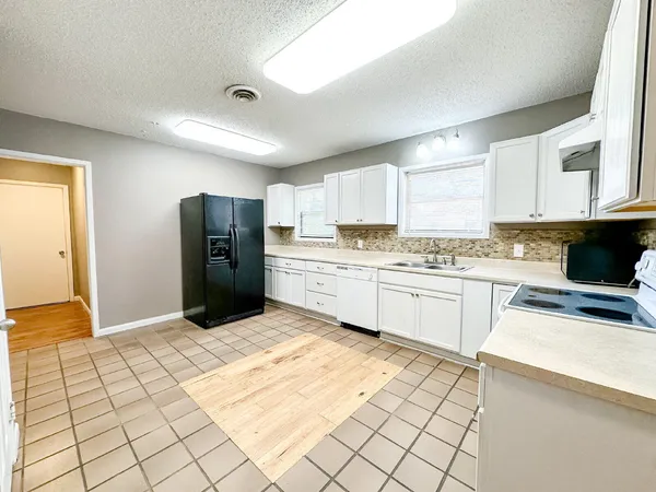 a kitchen with stainless steel appliances a refrigerator sink and cabinets
