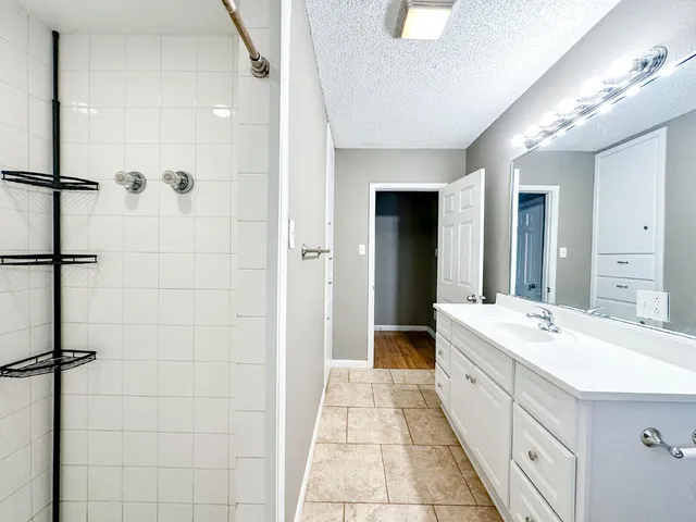 a large bathroom with a double vanity sink mirror and shower