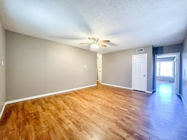 a view of an empty room with wooden floor