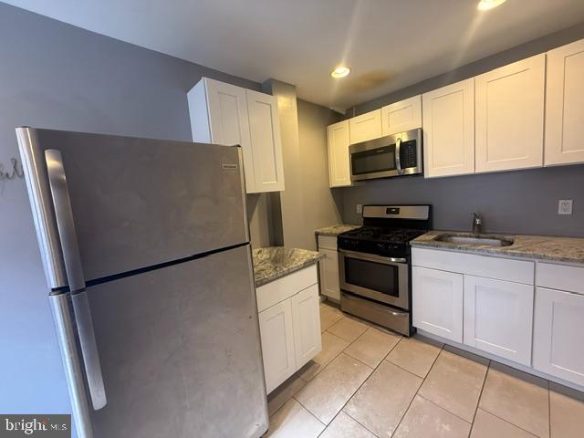 1224 Tasker Street, Unit 1R Philadelphia, PA 19148 - Photo 2 of 9 a white refrigerator freezer sitting in a kitchen
