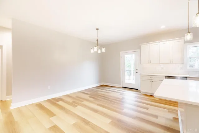 a large kitchen with granite countertop a white stove top oven and white cabinets
