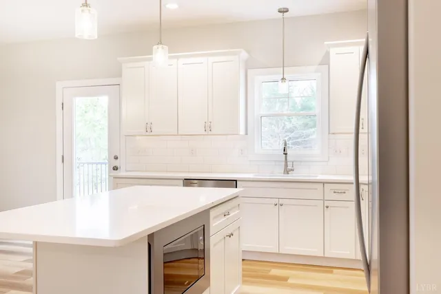 a large kitchen with kitchen island a sink stainless steel appliances and cabinets