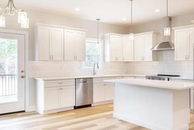 a view of a kitchen with kitchen island a sink stainless steel appliances and cabinets