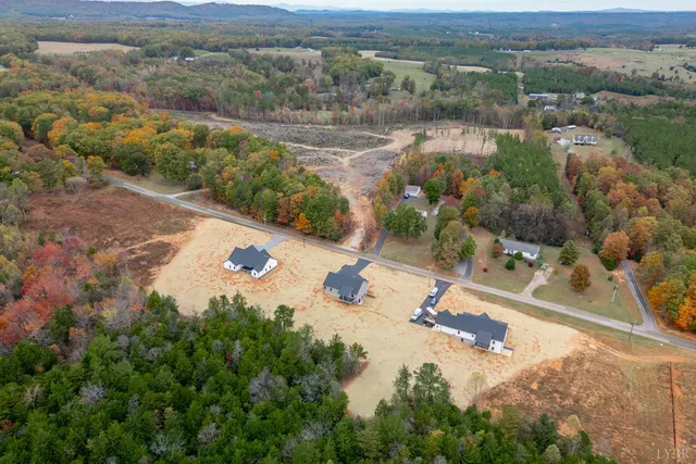 a view of a house with a yard and mountain view in back