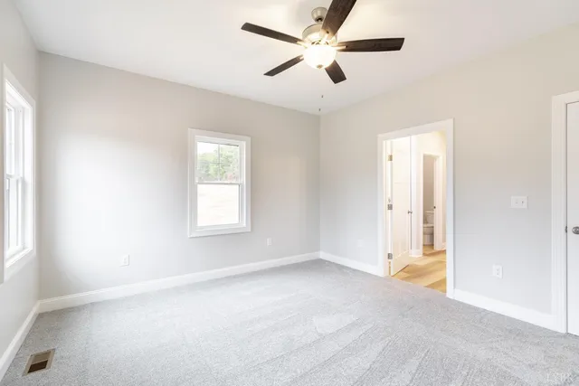an empty room with a window and a fan