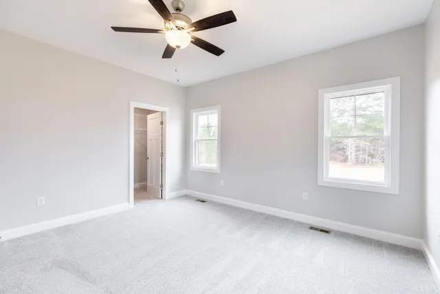an empty room with a window and a fan