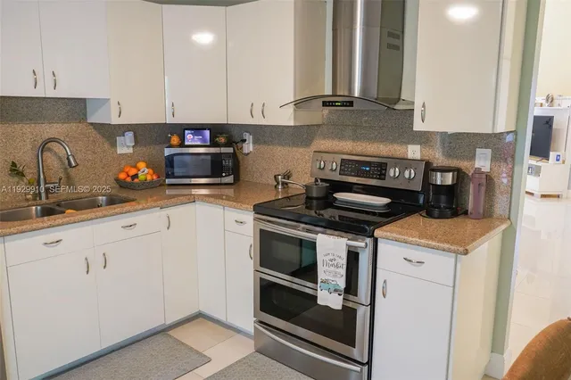 a kitchen with a sink and a stove with wooden floor