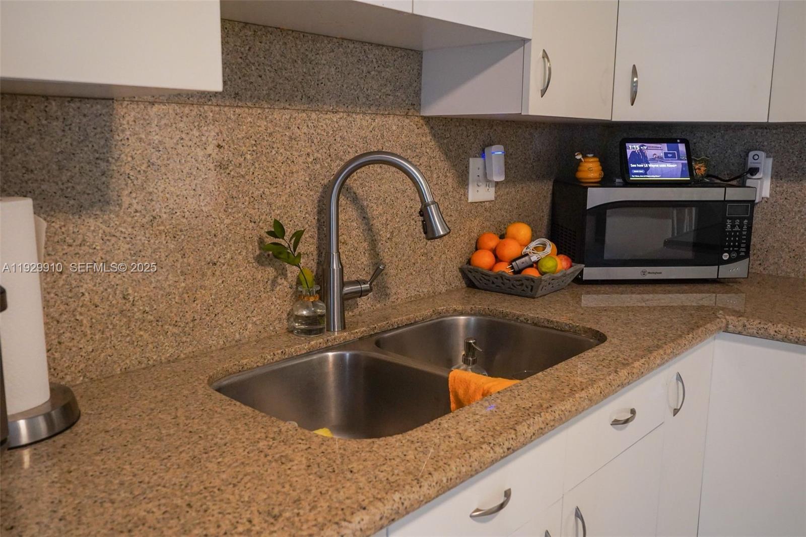 19907 Northwest 67th Court Hialeah, FL 33015 - Photo 14 of 53 a kitchen with a sink and a stove with wooden floor
