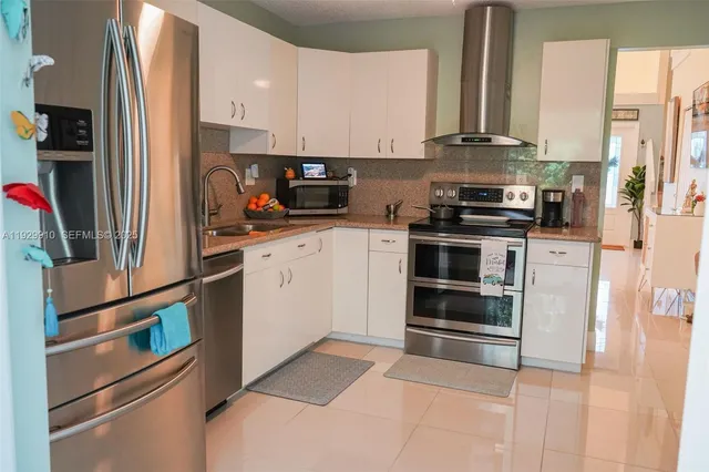a kitchen with appliances a refrigerator and cabinets