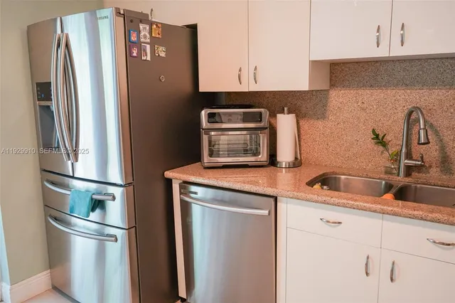 a room with stainless steel appliances a refrigerator and a stove top oven
