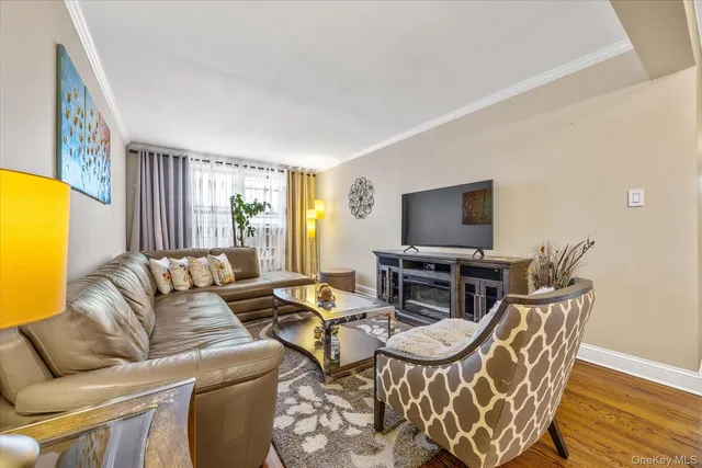 a living room with furniture a flat screen tv and a window