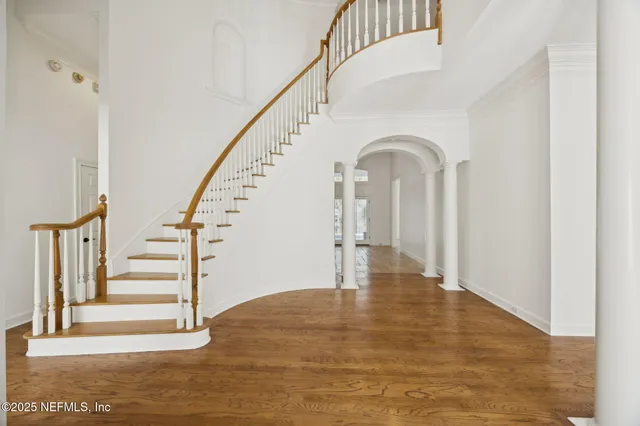 a view of a hallway with wooden floor and dining room