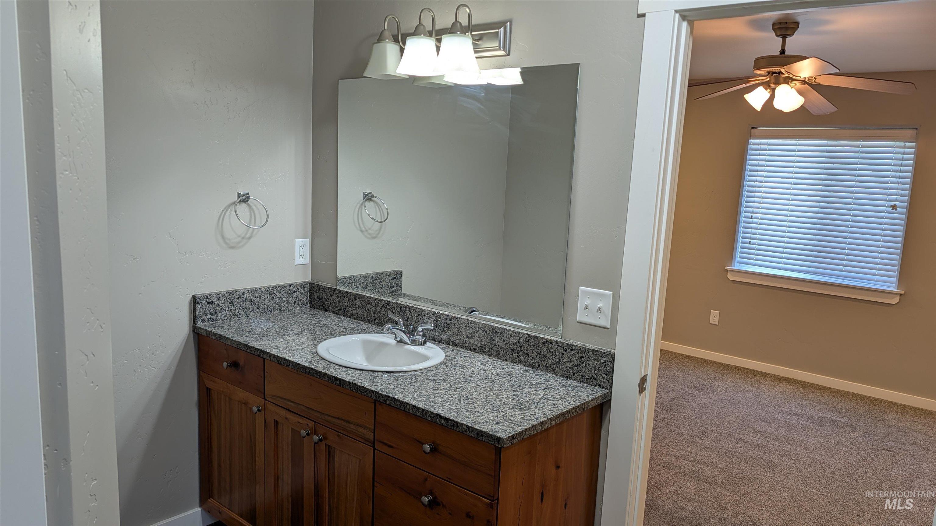 622 Lochsa Loop Heyburn, ID 83336 - Photo 10 of 17 Bathroom vanity featuring a granite countertop with an integrated sink and wood-finish cabinetry