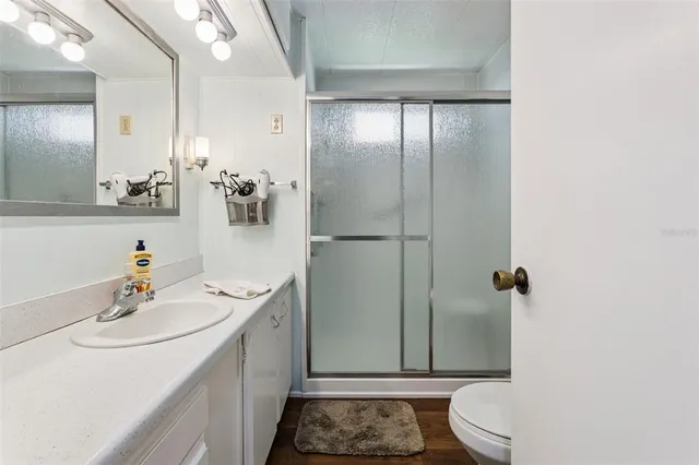 a bathroom with a sink a toilet and shower