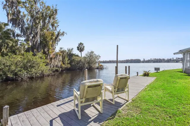 a view of a lake with couches chairs and wooden floor