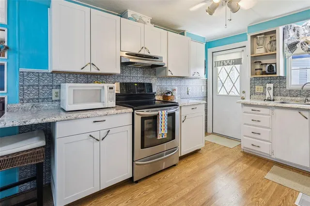 a kitchen with granite countertop white cabinets and white appliances