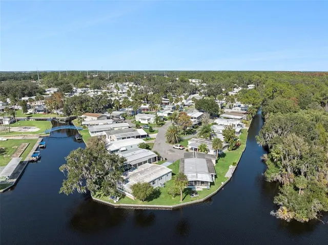 an aerial view of residential houses with outdoor space and trees