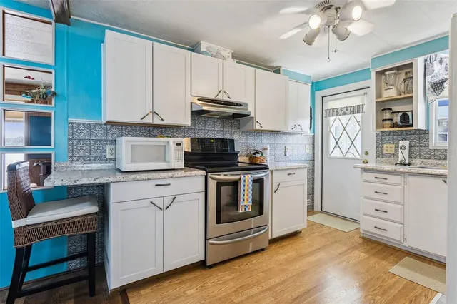 a kitchen with stainless steel appliances granite countertop a stove and cabinets