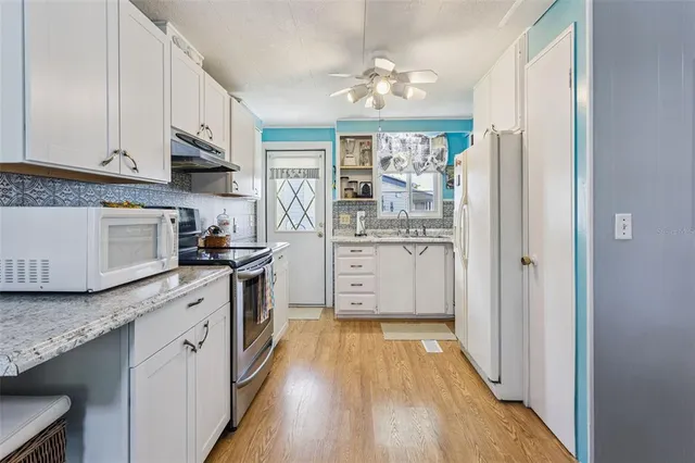 a kitchen with stainless steel appliances granite countertop a lot of counter space and wooden floor