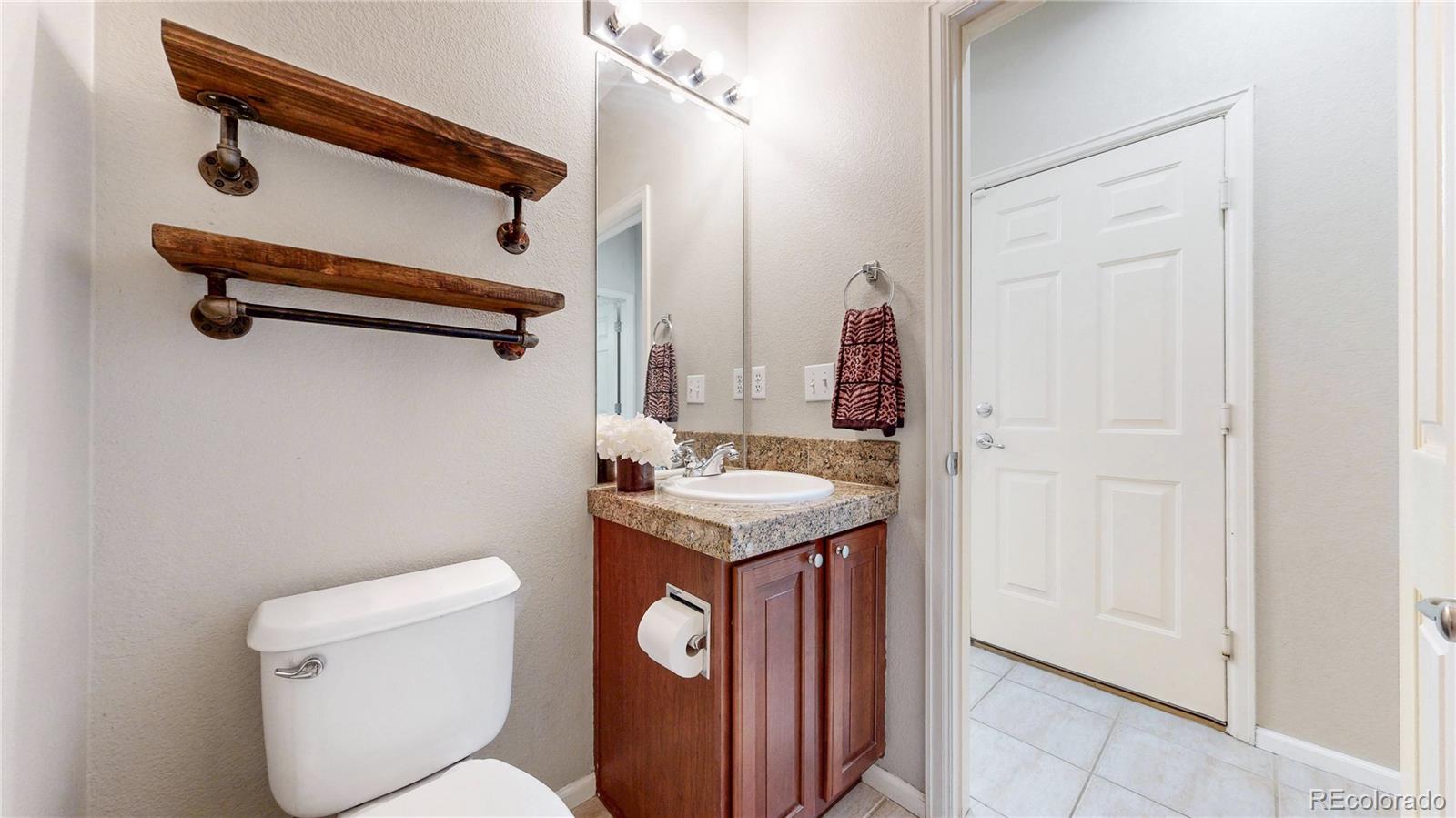 10797 Hickory Ridge Street Highlands Ranch, CO 80126 - Photo 11 of 42 a bathroom with a granite countertop sink a toilet and a mirror