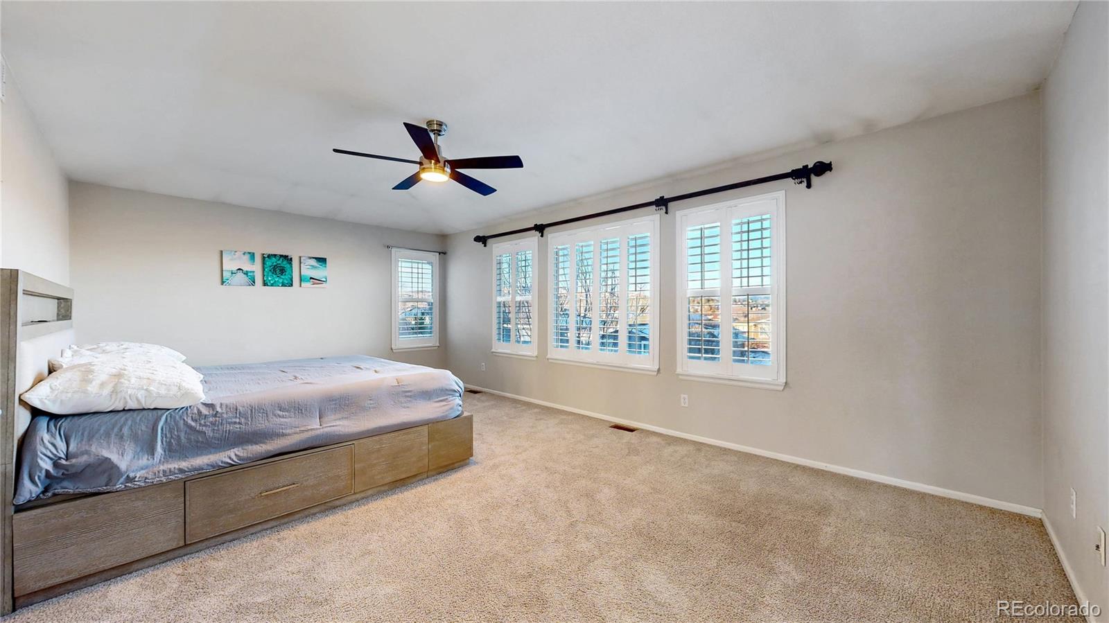 10797 Hickory Ridge Street Highlands Ranch, CO 80126 - Photo 13 of 42 a spacious bedroom with a bed and a chandelier