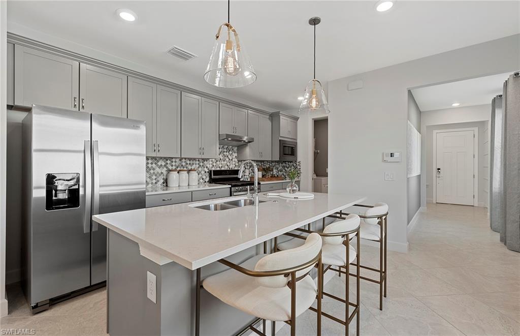 2142 Yellowfin Circle Naples, FL 34114 - Photo 8 of 31 a kitchen with kitchen island a counter top space appliances and cabinets
