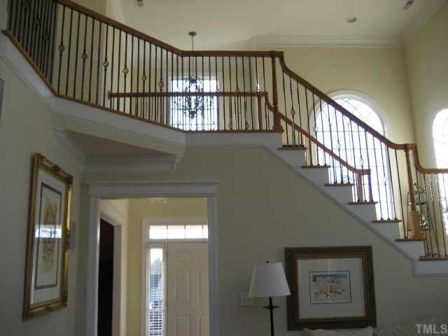 1132 Coram Fields Road Wake Forest, NC 27587 - Photo 2 of 10 Standing in 2-story great rm looking at stunning stairwell w/iron grillwork, solid oak treads, spacious landing,distinctive arched-church-like windows~spacious foyer~gorgeous thick moldings!