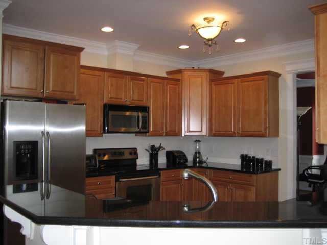1132 Coram Fields Road Wake Forest, NC 27587 - Photo 6 of 10 Tons of upgraded maple cabinets w/black granite counters, upgraded stainless steel appliances, eat-on bar, recessed lighting, HW floors~refrigerator does not convey.