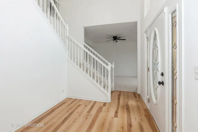 a view of a hallway with wooden floor and entryway