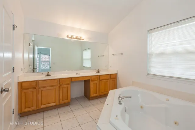 a spacious bathroom with a tub sink and mirror