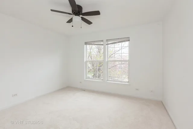 an empty room with a window and a fan