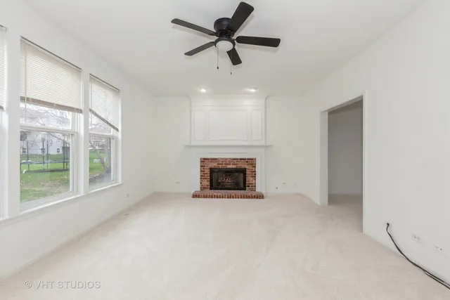 a view of an empty room with a fireplace and a window
