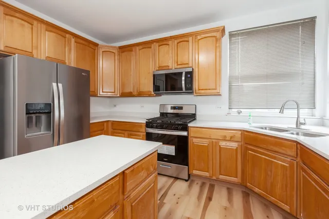 a kitchen with stainless steel appliances a refrigerator stove and sink