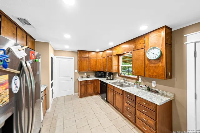 a large kitchen with stainless steel appliances granite countertop a stove a sink and a refrigerator