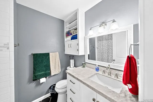 a bathroom with a bathtub sink vanity mirror and toilet