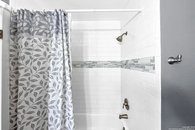 a bathroom with a shower curtain and a window