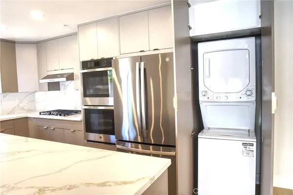 a kitchen with stainless steel appliances granite countertop a refrigerator and a stove