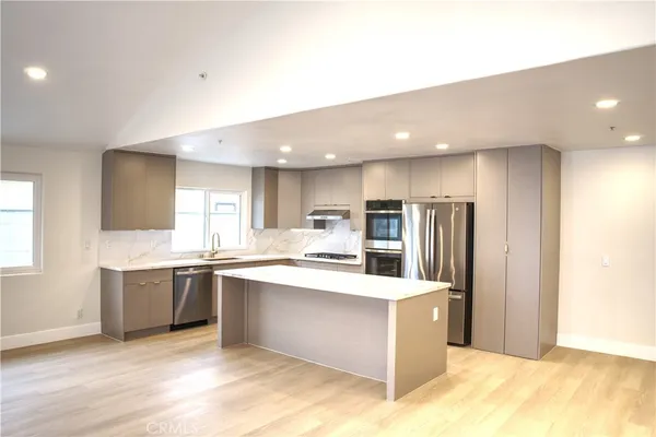 a large kitchen with stainless steel appliances lots of counter top space cabinets and a sink