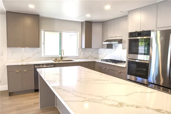 a kitchen with granite countertop a sink and stainless steel appliances