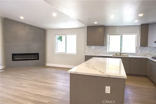 a kitchen with granite countertop a sink a stove and a microwave