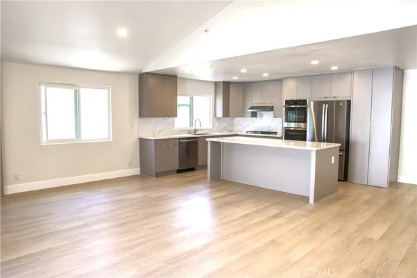 a large kitchen with stainless steel appliances granite countertop a stove and cabinets