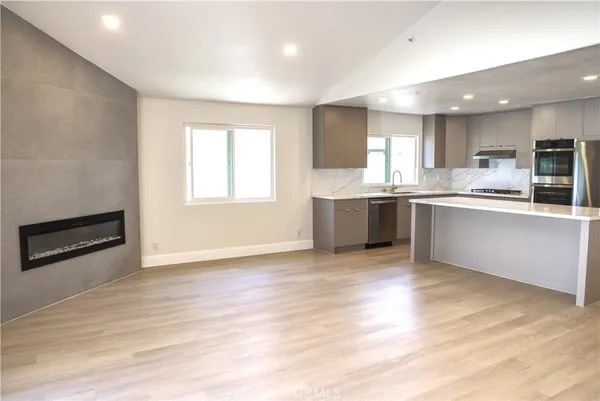 a large kitchen with stainless steel appliances granite countertop a stove a sink and a microwave
