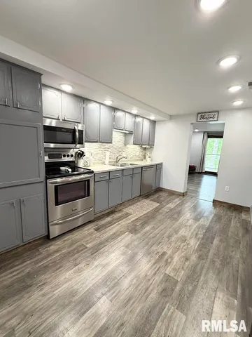a kitchen with stainless steel appliances granite countertop a stove a sink and a refrigerator