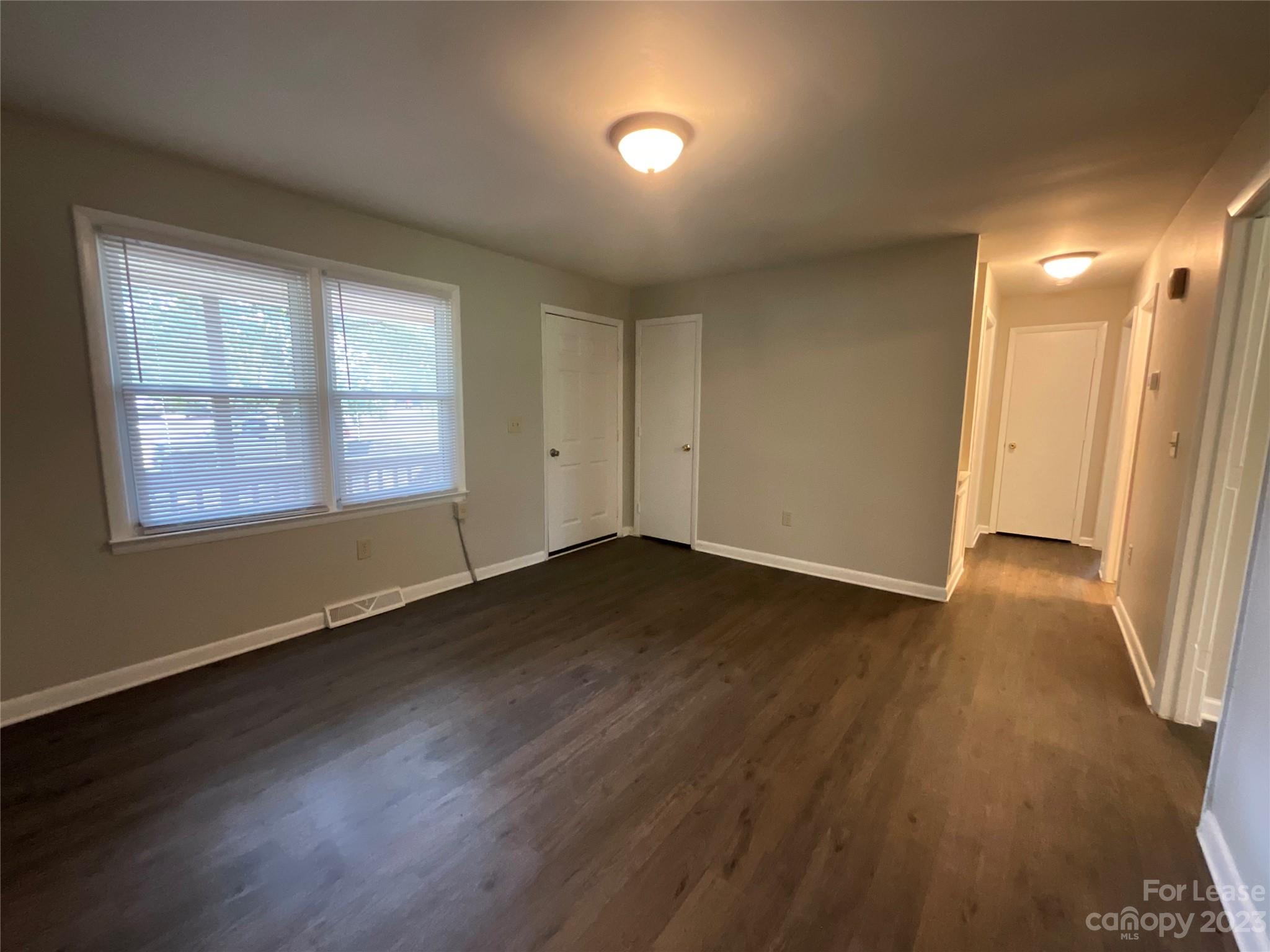 2006 Airport Road, Unit B Salisbury, NC 28147 - Photo 5 of 12 a view of an empty room with wooden floor and a window