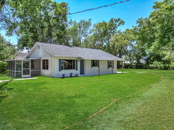 a aerial view of a house next to a yard with big trees