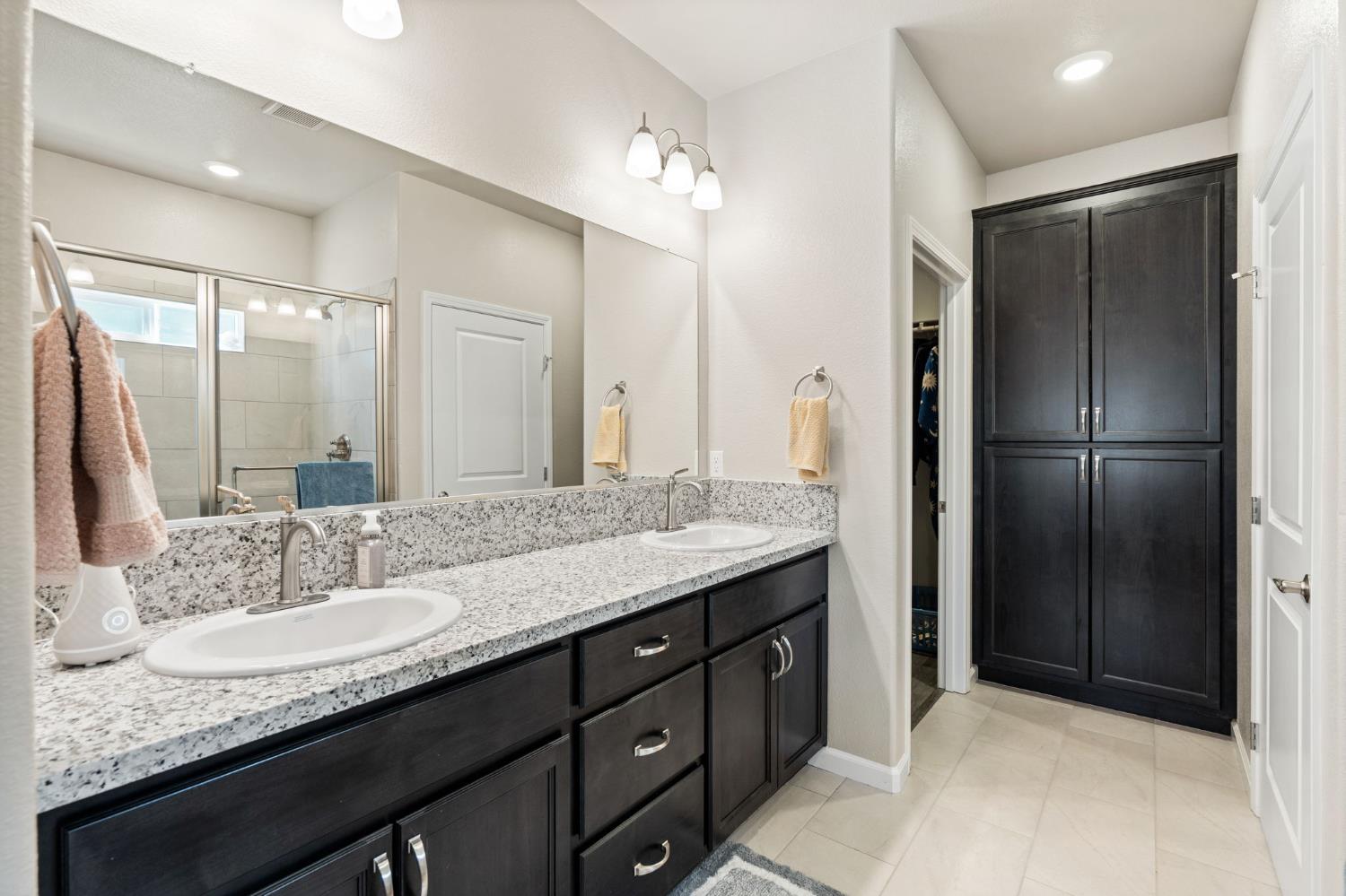 948 Hogan Road Galt, CA 95632 - Photo 11 of 20 a bathroom with a granite countertop sink and a mirror