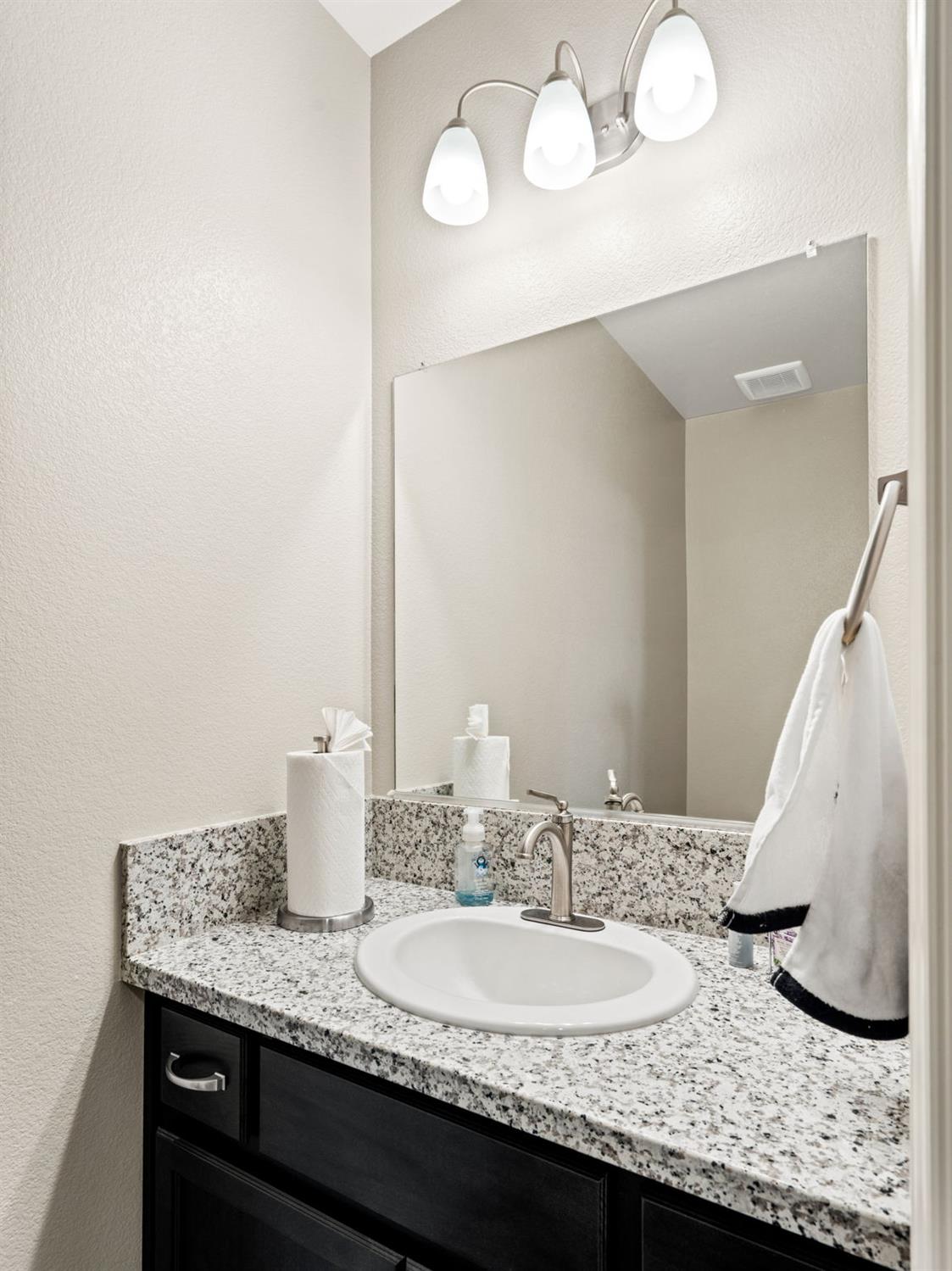 948 Hogan Road Galt, CA 95632 - Photo 5 of 20 a bathroom with a granite countertop sink and a mirror