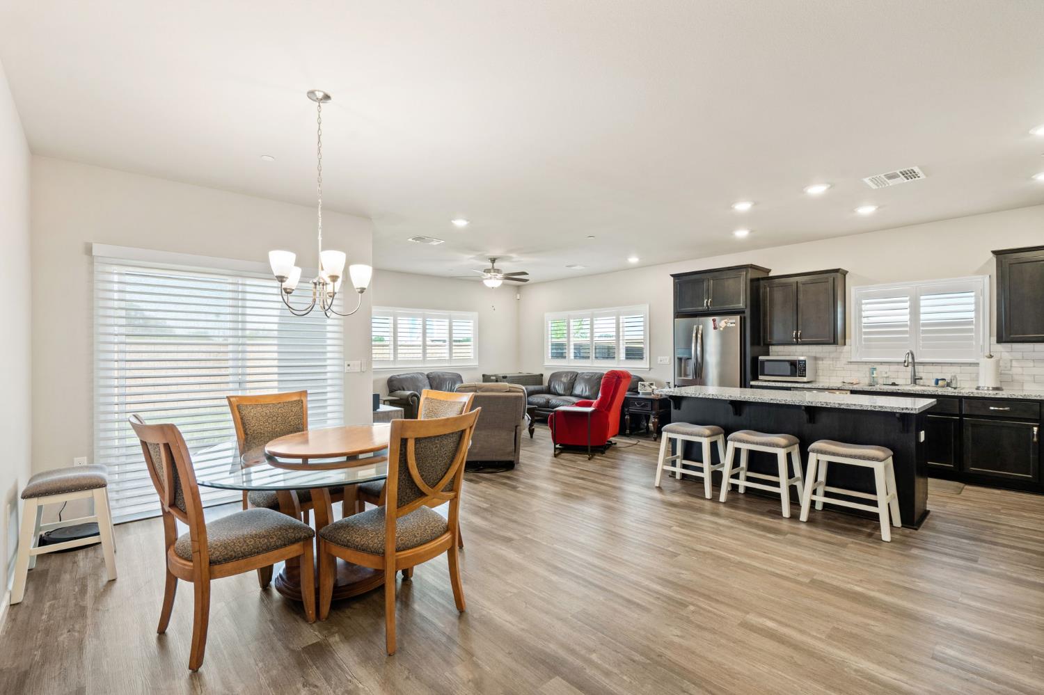948 Hogan Road Galt, CA 95632 - Photo 6 of 20 a view of a dining room and livingroom with furniture wooden floor a chandelier