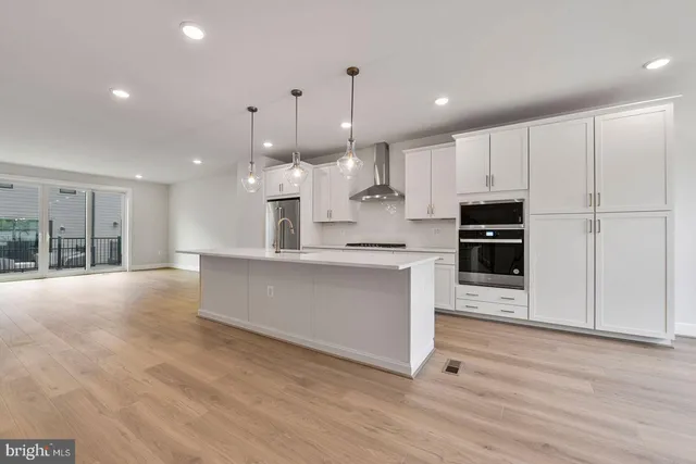 a large kitchen with kitchen island a sink stainless steel appliances and cabinets
